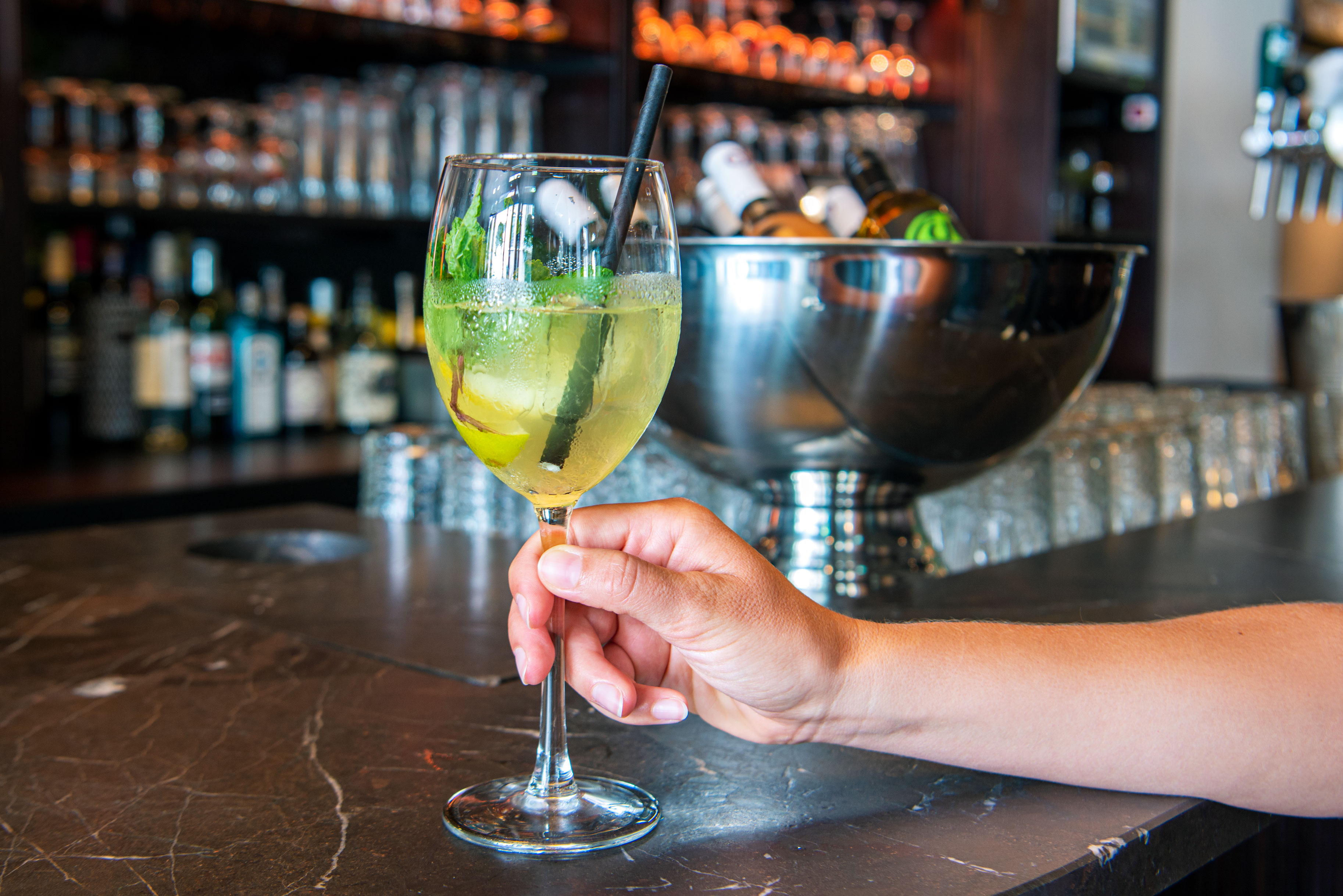 A girl holding a cocktail in her hand at the bar